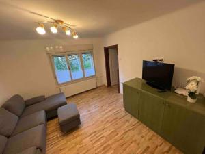 a living room with a couch and a flat screen tv at Tiny Bled house in Bled