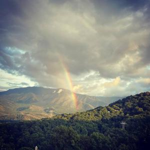 a rainbow in the sky over a mountain at Comfy Condo With Amazing View of Gatlinburg and the Smokies in Gatlinburg