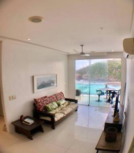 a living room with a couch and a table at Lindo Flat praia deserta búzios in Armacao dos Buzios