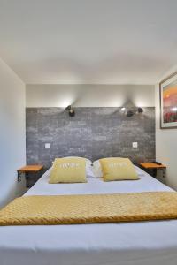 ein Schlafzimmer mit einem Bett mit zwei Kissen darauf in der Unterkunft CHALET CAMPAGNE Les Belles Ouvrières in Clermont-Créans
