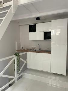 a white kitchen with white cabinets and a sink at Apartament Wspólna self check-in in Sosnowiec