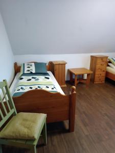 SurwoldにあるGästehaus Atrico Surwoldのベッドルーム1室(ベッド1台、椅子、ドレッサー付)