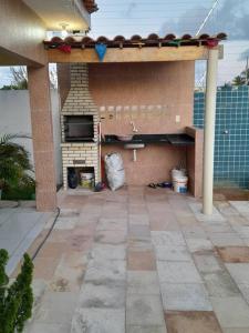 un patio con cucina all'aperto e camino di Bela casa de Veraneio - faça sua reserva. a Lucena