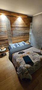 a bedroom with two beds and a wooden wall at Spa dans les Alpes in Desingy