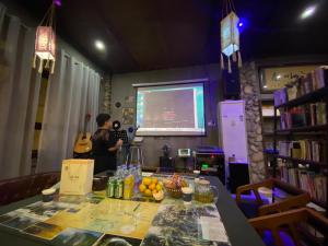 a man standing in front of a screen with a guitar at Zhangjiajie Highlights Guesthouse in Zhangjiajie