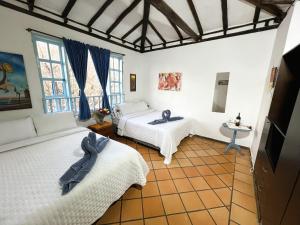 1 dormitorio con 2 camas y mesa. en Casa chalet Campestre 2km, en Villa de Leyva