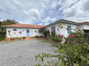 a large white house with a gravel driveway at Casa chalet Campestre 2km in Villa de Leyva