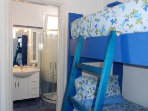 un letto a castello blu in un bagno con specchio di Bouganville Studios Stegna a Archangelos Altre 70 foto