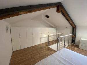 an attic room with white cabinets and wood floors at Savorgnan 1593 in Palmanova