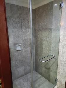 een douche met een glazen deur in de badkamer bij Times Square Apartment By Skyline in Kuala Lumpur