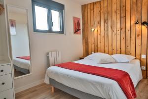 sypialnia z łóżkiem z drewnianą ścianą w obiekcie CHALET VINTAGE - Les Belles Ouvrières w mieście Clermont-Créans