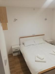 a bedroom with a white bed with two night stands at Vila Budimir in Pirot