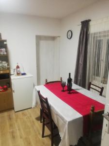 ein Zimmer mit einem Tisch mit einem roten Tischtuch darauf in der Unterkunft Vila Budimir in Pirot