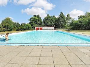 a woman is standing in a large swimming pool at 6 person holiday home in Fårvang in Fårvang