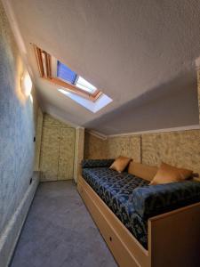 ein kleines Schlafzimmer mit einem Bett und einem Dachfenster in der Unterkunft Casa Vittoria Sirmione Punta Grò con Piscina in Sirmione