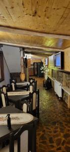 a dining room with tables and chairs and wooden ceilings at PENSIUNEA Mari Haus in Poiana Mărului