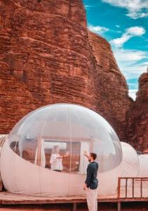 a man taking a picture of a couple in a dome at Joker camp Wadi Rum in Disah