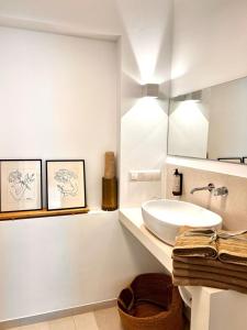 un bagno bianco con lavandino e specchio di ADI BOUTIQUE HOUSE a Salonicco