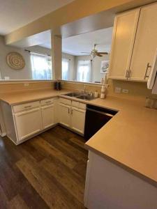 a large kitchen with white cabinets and a sink at Family home on fescue in Aurora