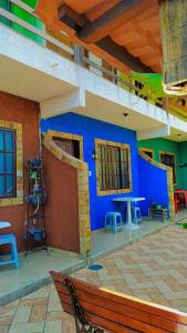 a room with a blue wall and tables and chairs at Vila da Drika in Rio das Ostras