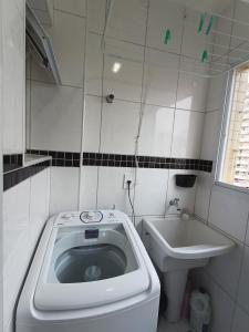 a small bathroom with a toilet and a sink at Apê com churrasqueira guilhermina in Praia Grande +23 photos