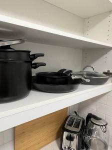 a shelf with pots and pans on it in a kitchen at Classy single family house, walk to St Boniface in Winnipeg