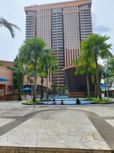 a resort with palm trees and a large building at Times Square Apartment By Skyline in Kuala Lumpur