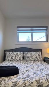 uma cama num quarto com uma janela e uma cama sidx sidx em Classy single family house, walk to St Boniface em Winnipeg