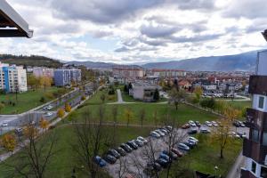 uma cidade com carros estacionados num parque de estacionamento em SUN APARTMAN AIRPORT SARAJEVO em Sarajevo