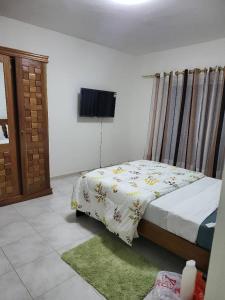 a bedroom with a bed and a television on the wall at Jado house 4 in Dakar