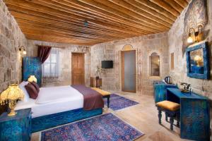 een slaapkamer met een bed en een stenen muur bij Cappadocia Pema Cave Hotel in Ortahisar