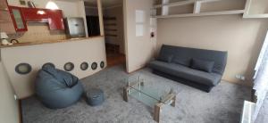 un soggiorno con divano blu e tavolo in vetro di 2 pokojowy apartament a Stettino