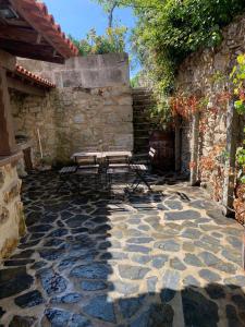 a patio with a bench and a stone wall at Casa da Maria Reguila in Porto