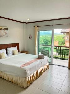 a bedroom with a large bed and a large window at Pai happyvillage_yeon in Ban Thung Pong