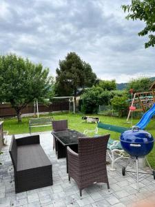 eine Terrasse mit einem Tisch und Stühlen sowie einem Spielplatz in der Unterkunft Villa Kunterbunt in Knittelfeld