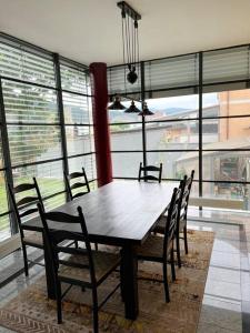 una mesa de comedor y sillas en una habitación con ventanas en Villa Kunterbunt, en Knittelfeld