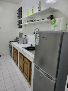 a kitchen with a stainless steel refrigerator and wooden cabinets at Jado house 4 in Dakar