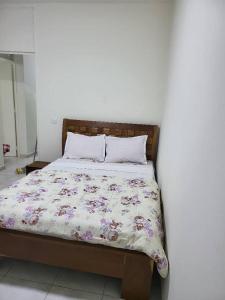 a bed with a floral comforter in a bedroom at Jado house 4 in Dakar
