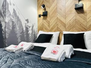 a bedroom with a bed with white towels on it at Apartament Nad Strumykiem z SAUNĄ - 5D Apartamenty in Szklarska Poręba
