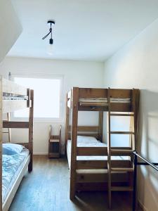 Pokój z 3 łóżkami piętrowymi i lampą w obiekcie Panorama View - CharmingStay w mieście Flumserberg