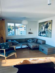 sala de estar con sofá y mesa en Panorama View - CharmingStay, en Flumserberg