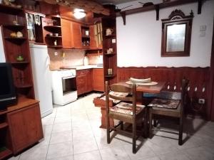 a kitchen with wooden cabinets and a table and chairs at Dunavski konaci in Brestovik