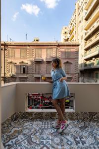 una ragazza in piedi sul bordo di un balcone di Lemon Spaces VINTAGE- Downtown a Il Cairo