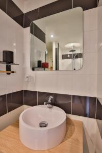 a bathroom with a white sink and a mirror at CHALET CARAIBES SPA Privatif in Clermont-Créans