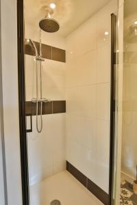a shower with a glass door in a bathroom at CHALET CARAIBES SPA Privatif in Clermont-Créans