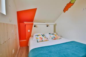 a bedroom with orange walls and a bed with two pillows at CHALET CARAIBES SPA Privatif in Clermont-Créans
