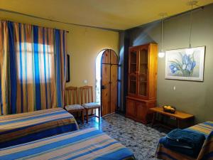 - une chambre d'hôtel avec 2 lits et une porte dans l'établissement Casa Proyecto Pepe Bravo - Arte de manos y corazón, à Alozaina