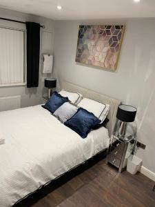 Un dormitorio con una cama con almohadas azules. en Crestfield Lodge, en Thamesmead