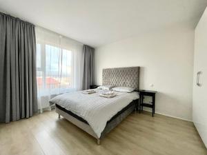 1 dormitorio con cama y ventana grande en Cosy stay with a great view! en Njarðvík