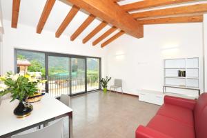 a living room with a red couch and a table at Agriturismo Tre Forti in Rivoli Veronese